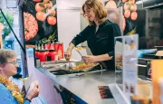 Medewerkster schept verse frietjes op in de mobiele frituur